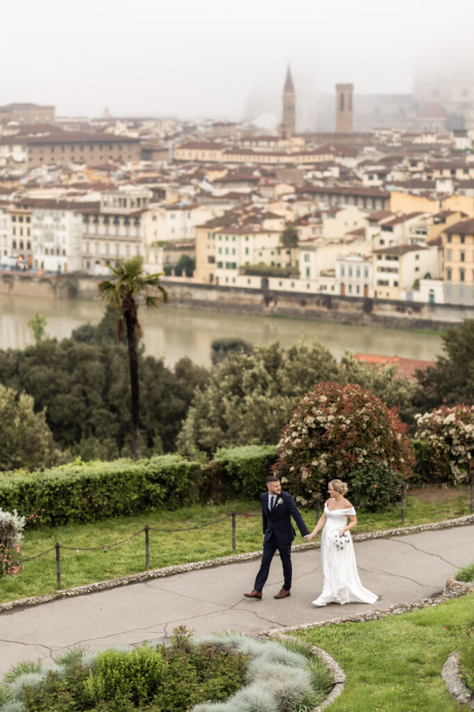 A couple in wedding gown walking in park with Florence as their background