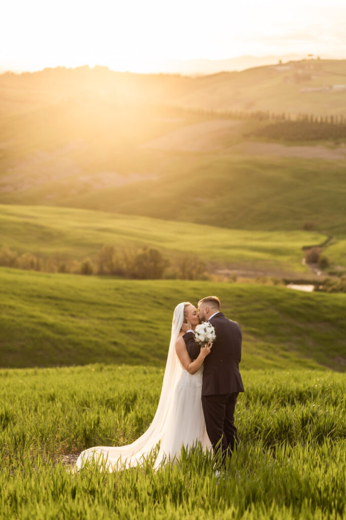 Couple standing on Tuscany hills reading their vows to each other at sunset.