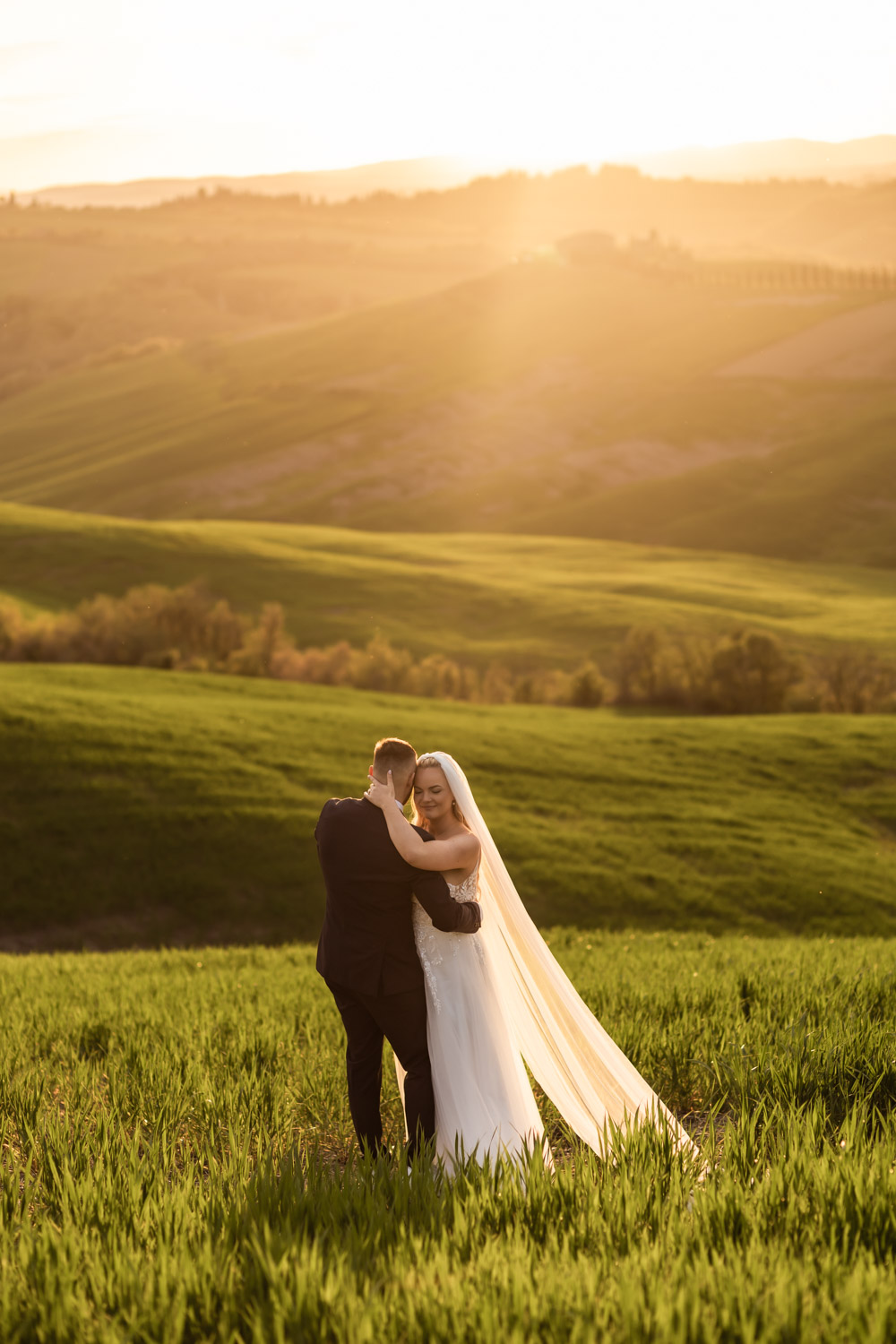 Couple standing on Tuscany hills reading their vows to each other at sunset.