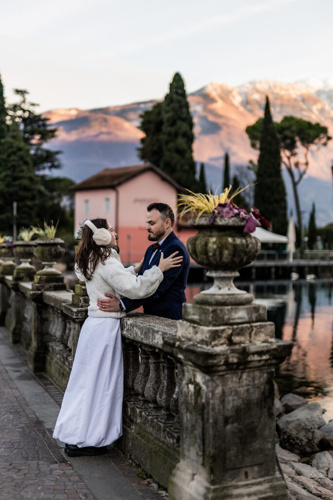 romantic bride and groom kissing on a bridge during a winter elopement in lake garda