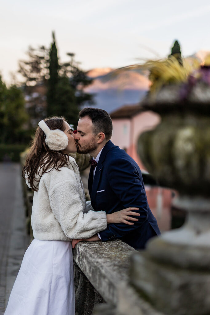 romantic bride and groom kissing on a bridge during a winter elopement in lake garda