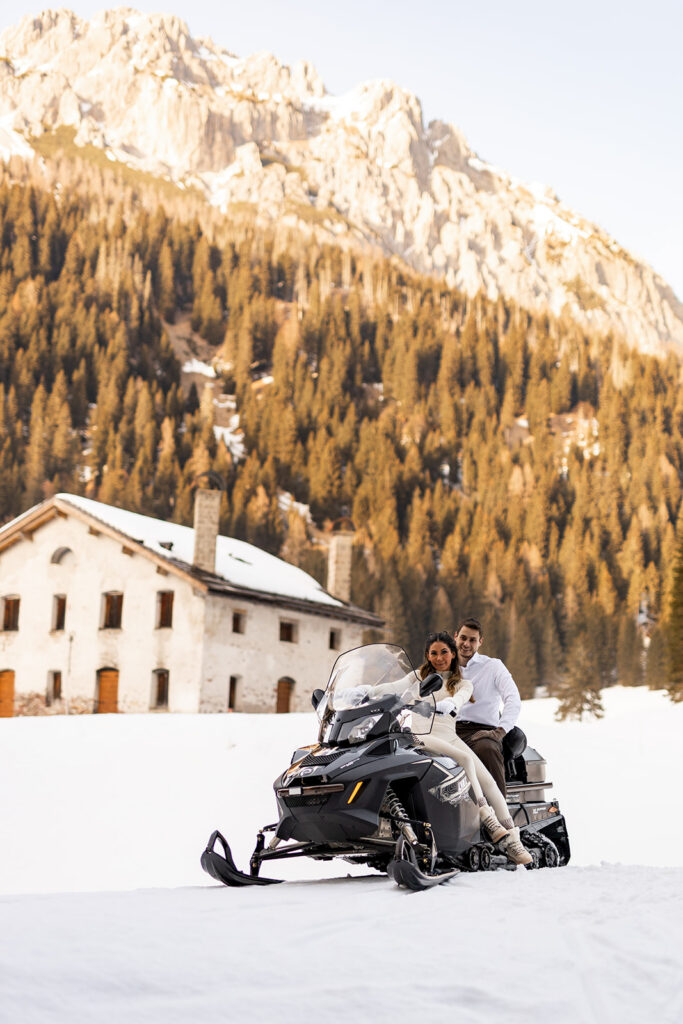 bride and groom riding a snowmobile during their adventure elopement in Dolomites
