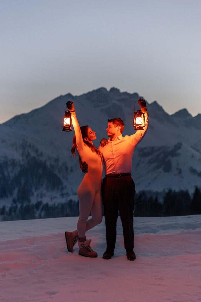 bride and groom posing with lanterns during dusk in the Dolomites
