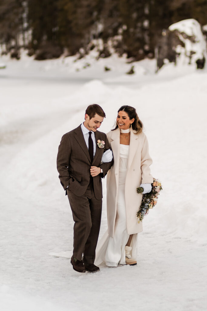 bride and groom exploring lake braies during their winter elopement in the dolomites