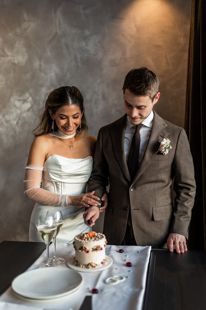 bride and groom cutting a cake during their Dolomites elopement day