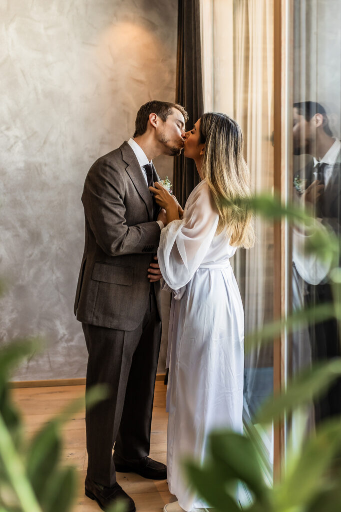 bride putting boutonniere ahead of their elopement in the Dolomites