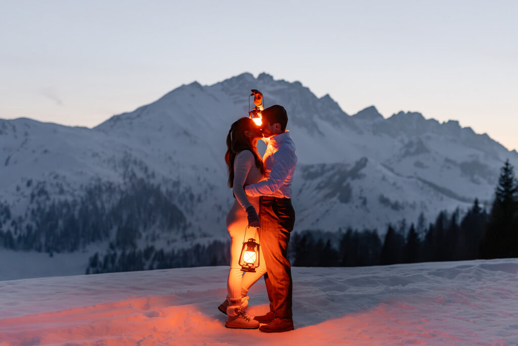 bride and groom posing with lanterns during dusk in the Dolomites
