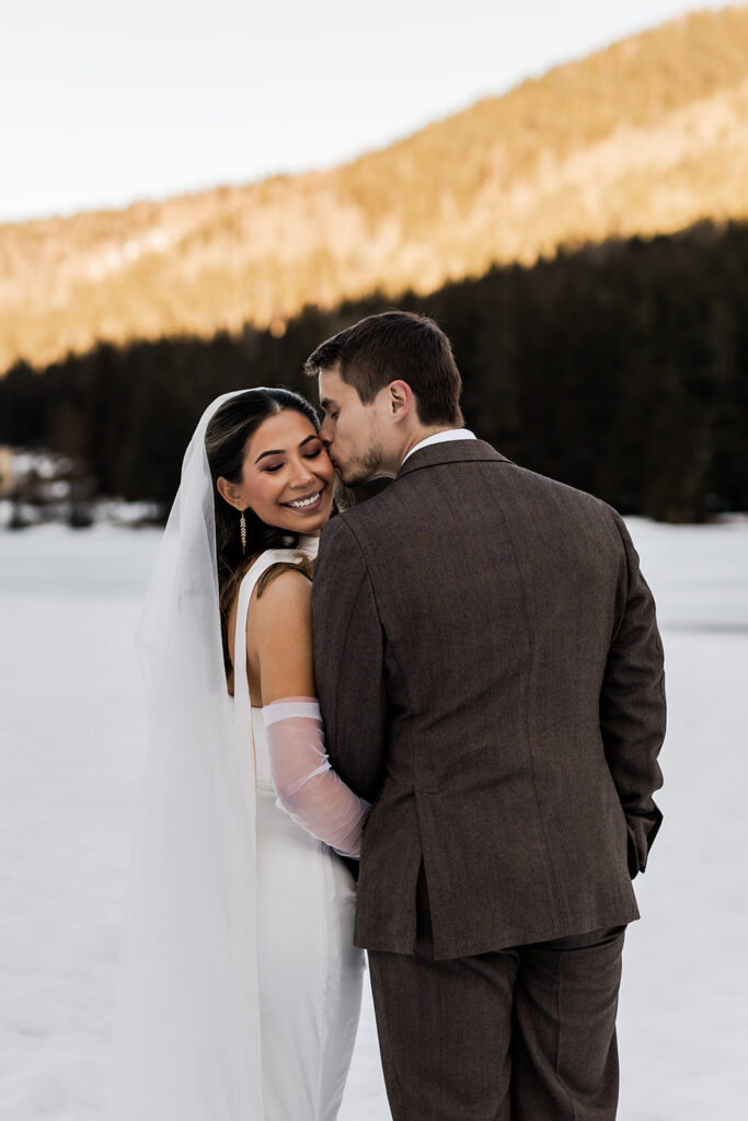 bride and groom standing in front of the snowy mountains in the Dolomites