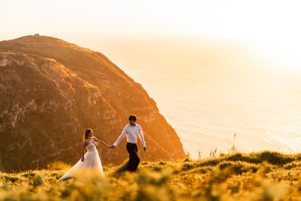 bride and groom walking while holding hands during their madeira elopement