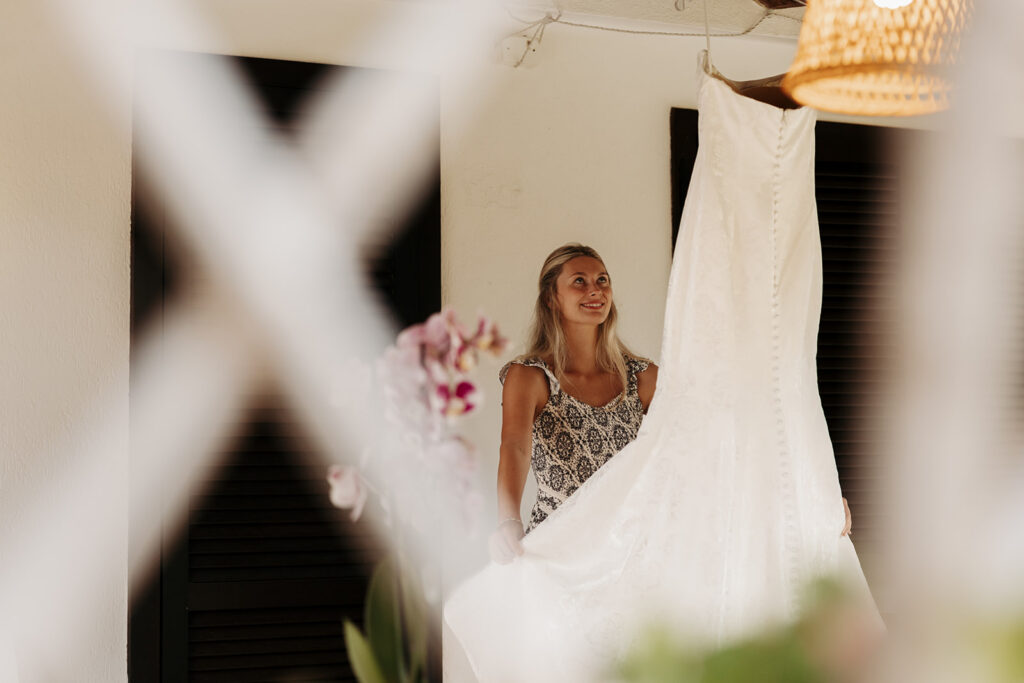 bride steaming wedding dress outside on the porch
