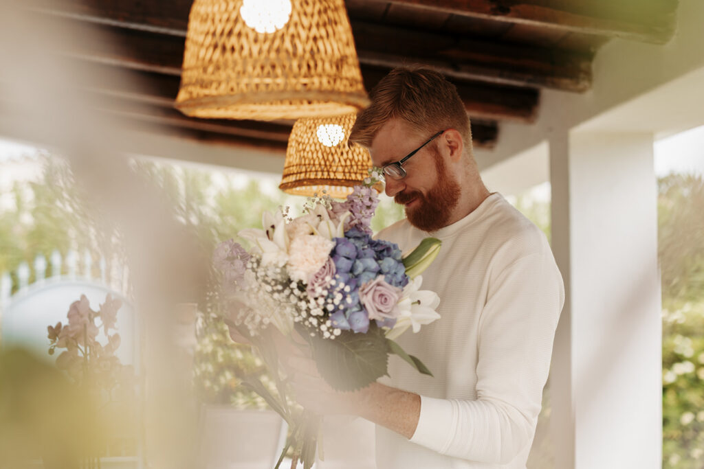 groom arranging a bouquet for his bride