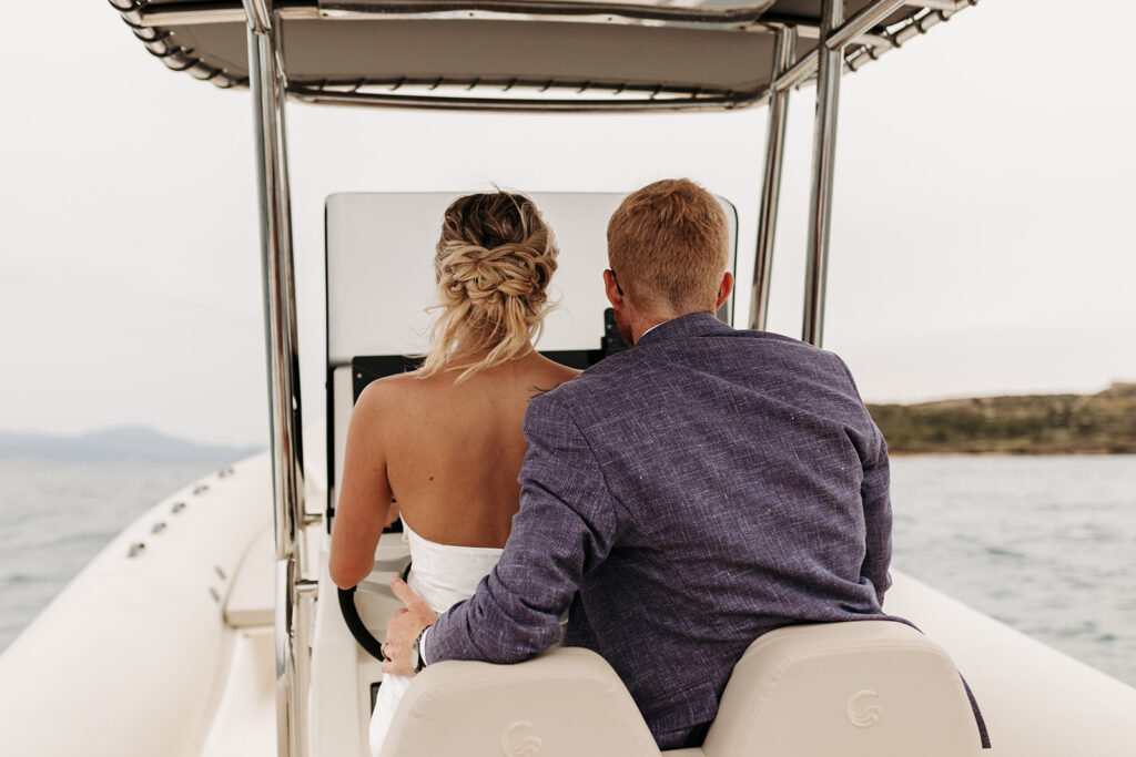 elopement couple steering the boat