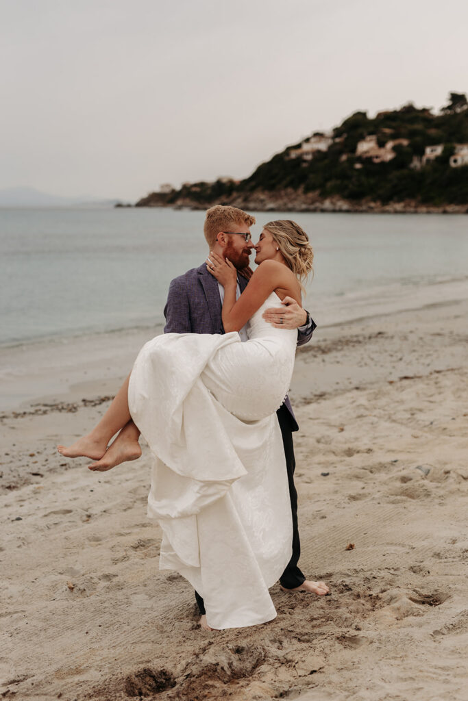 playful bride and groom at the beach in sardinia during blue hour