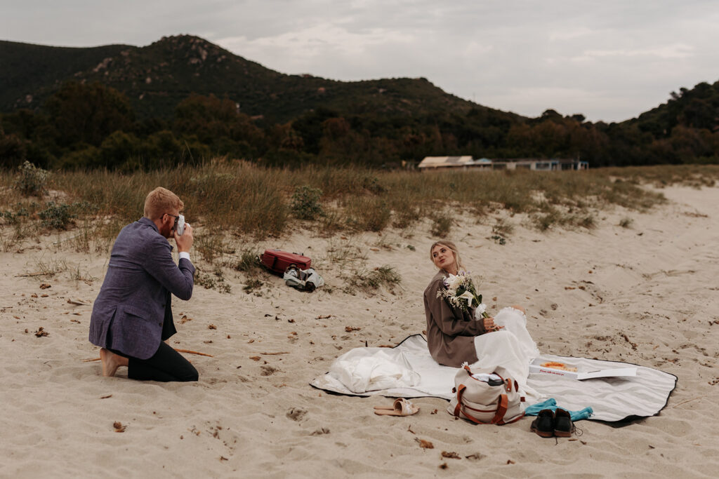 playful bride and groom at the beach in sardinia during blue hour