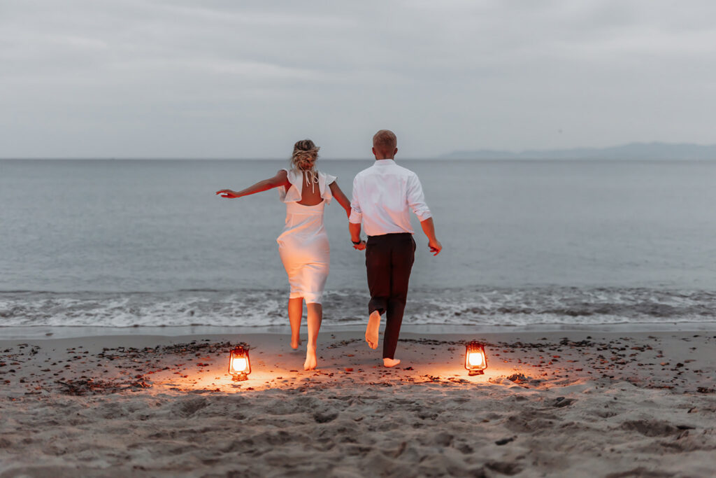 bride and groom with lanterns at the beach