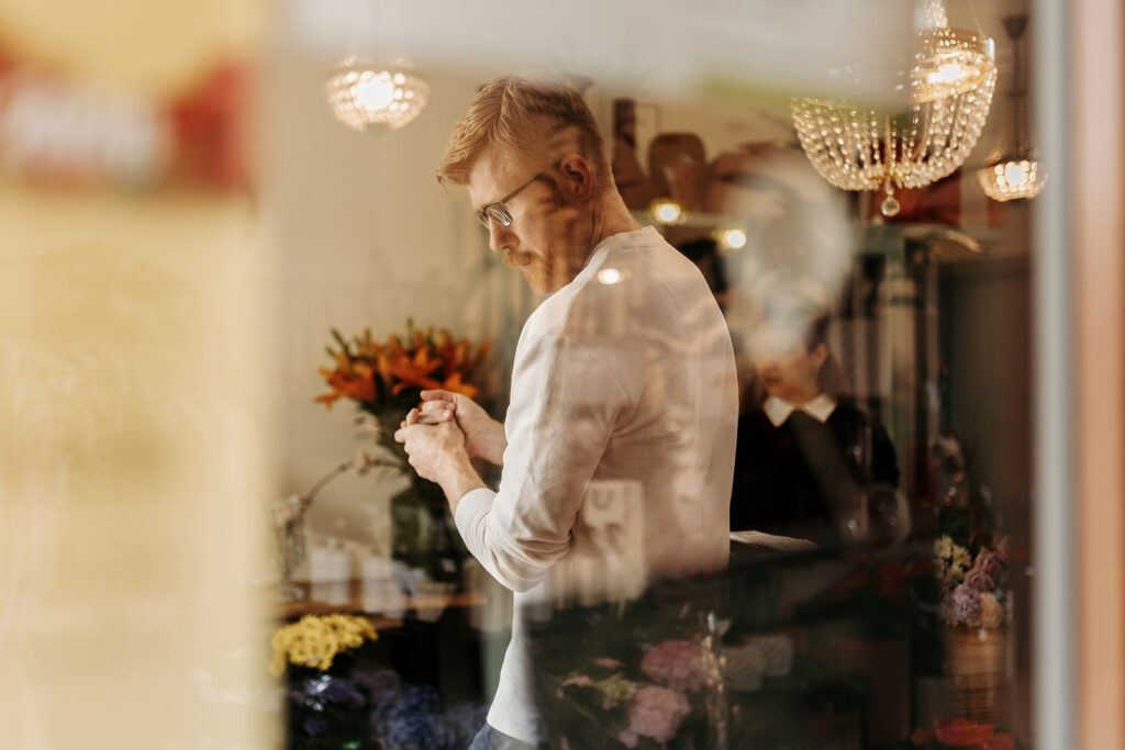 groom picking flowers at a flower shop