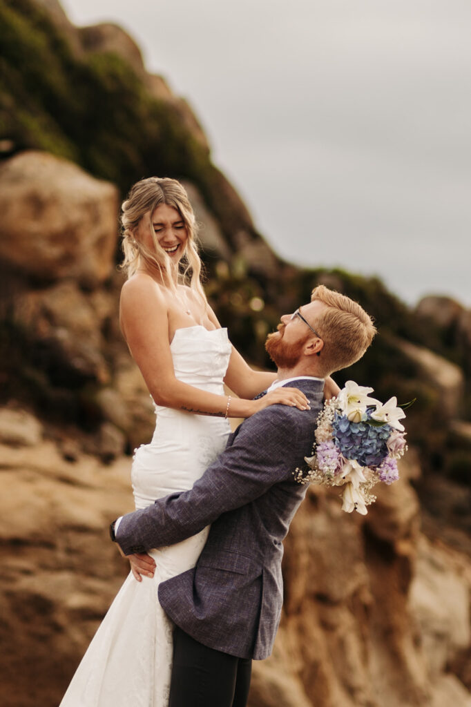 playful elopement couple on a small cliff during their sardinia elopement