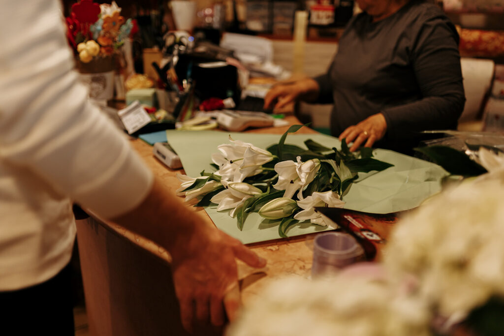 groom picking flowers at a flower shop