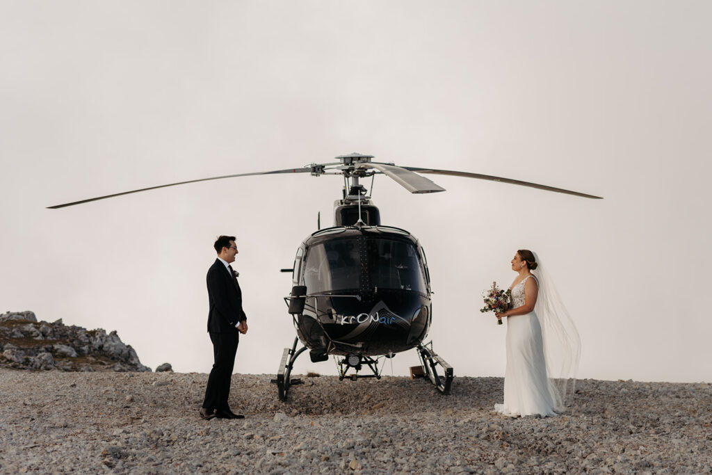 bride and groom standing next to the helicopter during their dolomites helicopter elopement