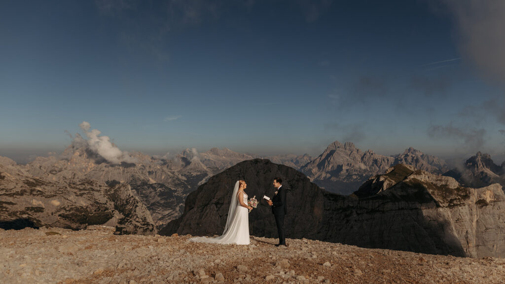 bride and groom exchanging vows on a mountain top in the dolomites