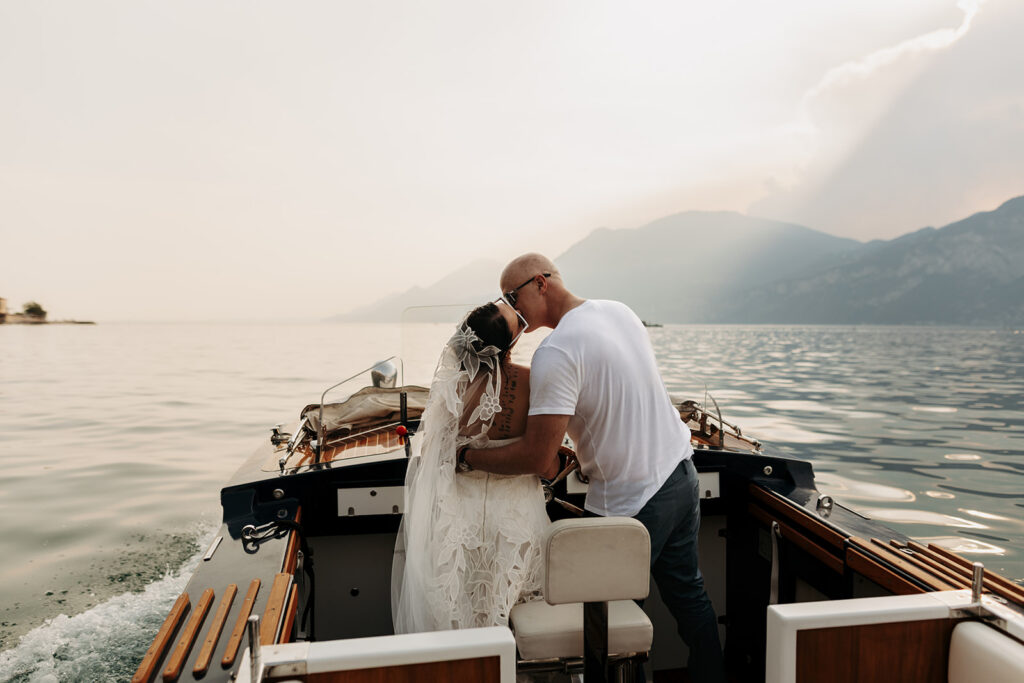 elopement couple kissing as they are steering a boat in lake como