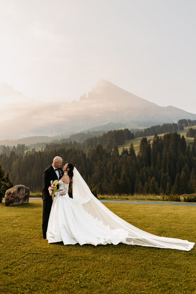 elopement couple standing in a lush lawn with the dolomites in the background