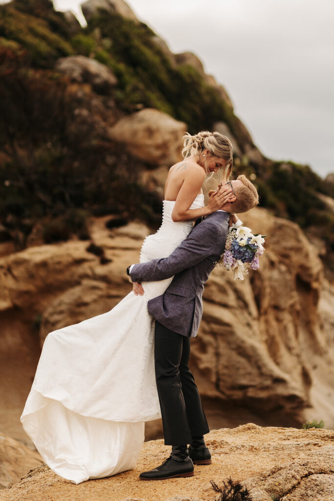 playful elopement couple on a cliff during their multi day elopement in sardinia