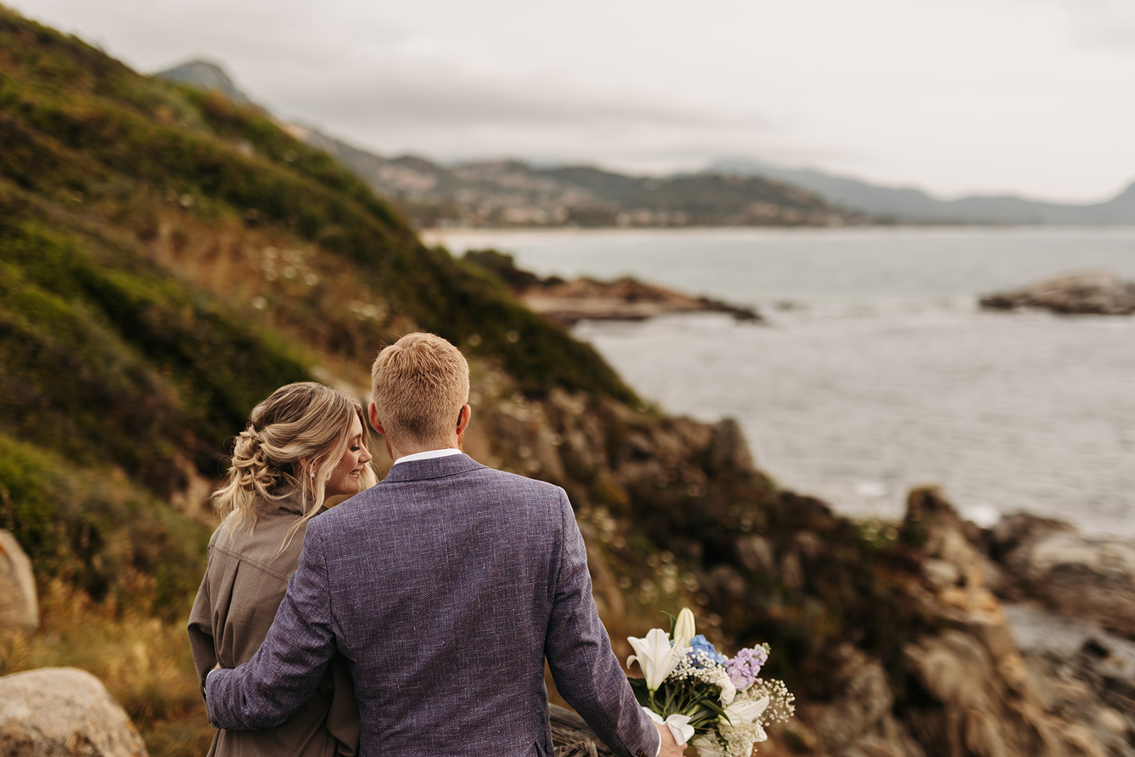playful elopement couple on a cliff during their multi day elopement in sardinia